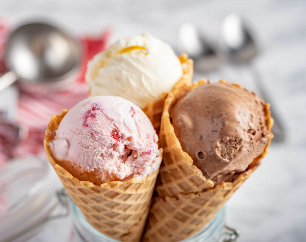 strawberry, vanilla, chocolate ice cream woth waffle cone on marble stone backgrounds